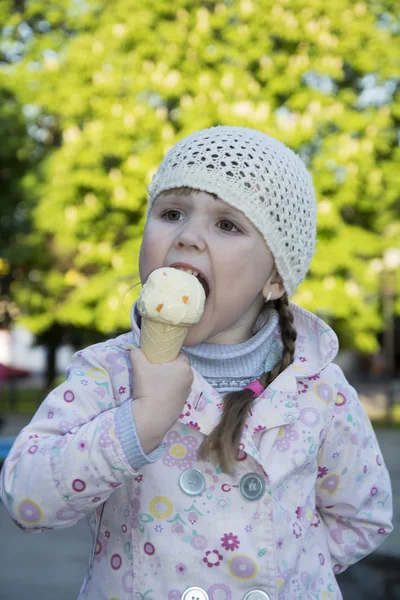 Na primavera na rua uma menina comendo sorvete . — Fotografia de Stock