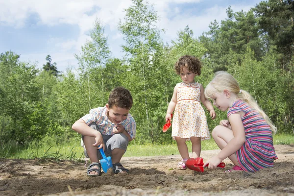 Im Sommer im Wald kleine Kinder auf dem Spielplatz umgraben. — Stockfoto