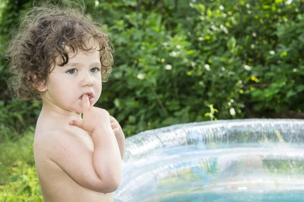 No verão, o jardim é banhado em uma menina inflável da piscina . — Fotografia de Stock