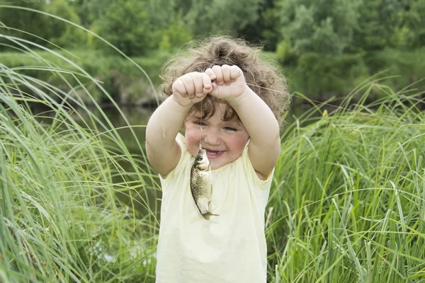 In de zomer van krullend meisje in ontzag van karper gevangen. — Stockfoto