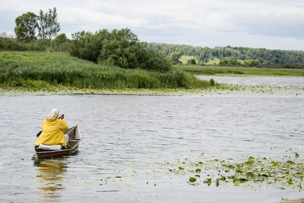 Летом, женщина-рыбак лодка плавает по реке с — стоковое фото