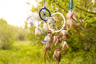 Gün batımında fotokopi alanı, sembol, gelenek ve işaretlerle düş kapanı. Boho stil yakalayıcıları rüzgarda gelişir, fotokopi alanı, sembolü, geleneği, işaretleri olan bitkilerin bulanık yeşil arka planına karşı. boho tarzı.