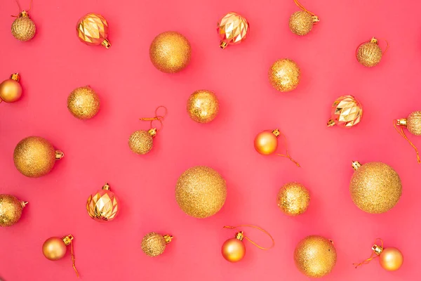 Gouden glitter. Kerstballen van verschillende maten op een roze achtergrond patroon. Vlakke lay, bovenaanzicht. — Stockfoto