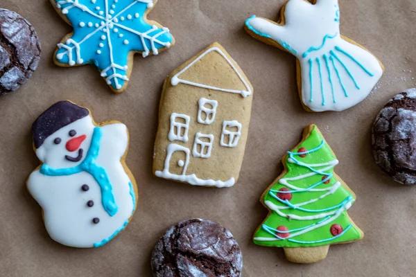 Gingerbread painted colored gingerbread cookies and spices and snowflakes on a craft background close-up. Christmas celebration concept. New Years food.