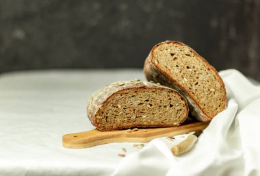 Tahtada siyah dilimlenmiş ekmek ve beyaz bir arka planda bıçak. Arka plan bulanık. Boşluğu kopyala