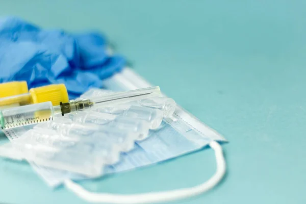 Medicinska injektionsflaskor för injektion, injektionsspruta, maskhandskar på blå bakgrund. Tillträdesvaccination, influensa skjuten. — Stockfoto