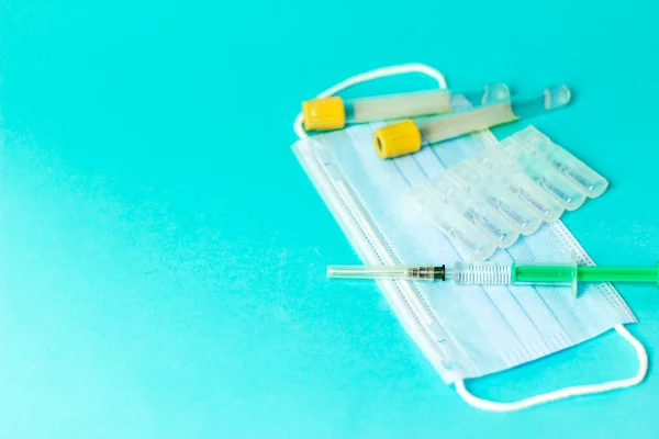 Медицинские ампулы для инъекций, шприц для инъекций, маска перчатки на синем фоне. Вакцинация, прививка от гриппа. — стоковое фото
