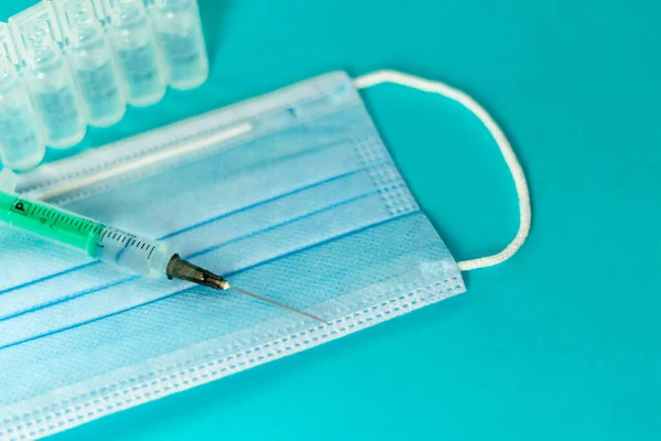 Medicinska injektionsflaskor för injektion, injektionsspruta, maskhandskar på blå bakgrund. Tillträdesvaccination, influensa skjuten — Stockfoto