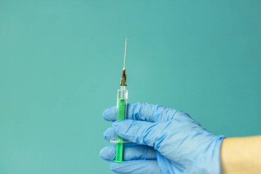 İğne için tıbbi şişeler, iğne için şırınga, mavi arka planda maske eldiveni. Giriş aşısı, grip aşısı..