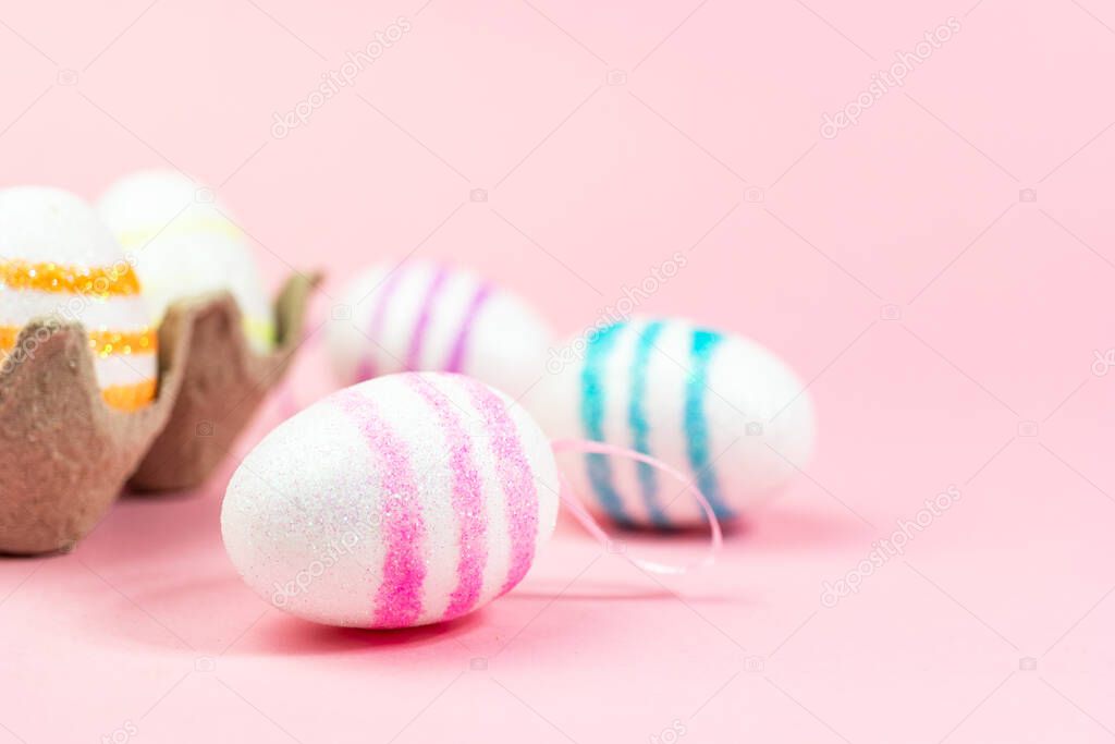 Colorful Easter eggs on a pink background. Copy space. Celebrating Easter.