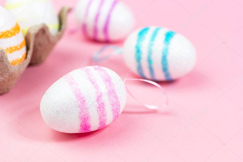 Colorful Easter eggs on a pink background. Copy space. Celebrating Easter.