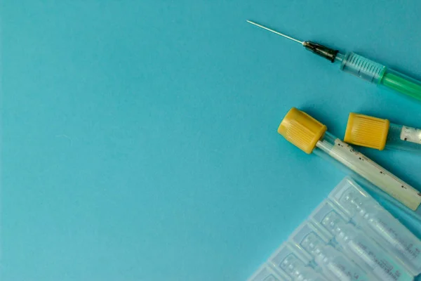 Medical vials for injection, syringe for injection, mask gloves on a blue background. Admission vaccination, flu shot.