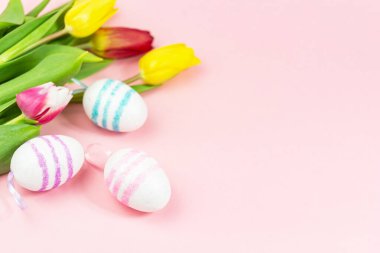 Paskalya, pembe arka planda lalelerle boyanmış yumurtalar. Uzayı kopyala Paskalya kutlaması kavramı