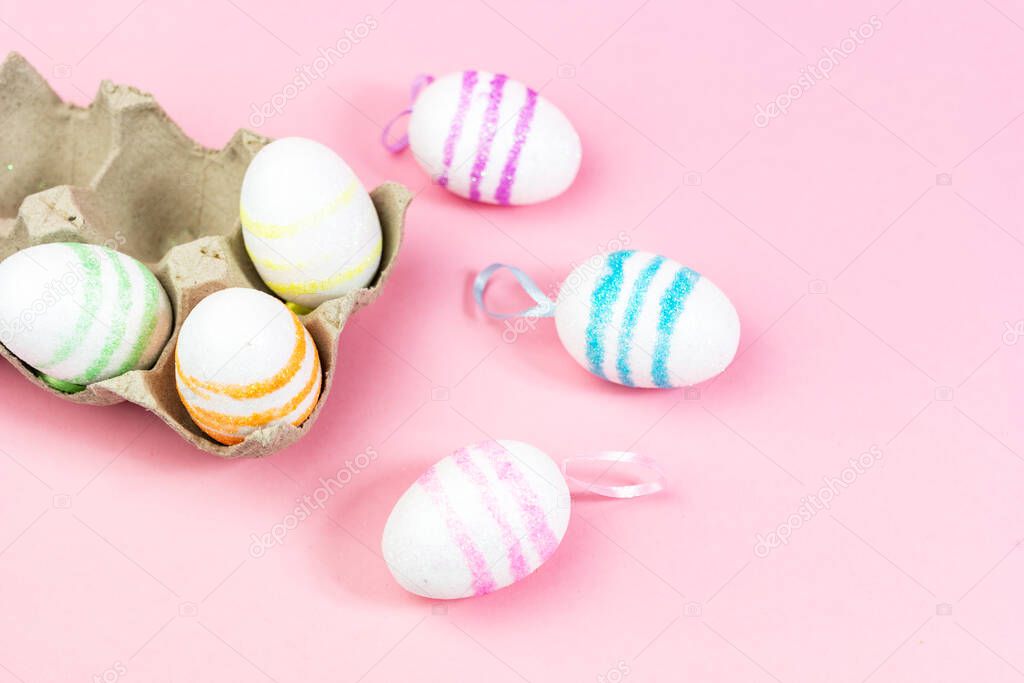 Colorful Easter eggs on a pink background. Copy space. Celebrating Easter.