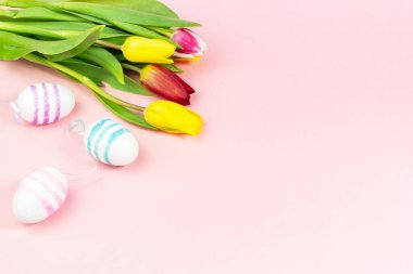 Paskalya, pembe arka planda lalelerle boyanmış yumurtalar. Uzayı kopyala Paskalya kutlaması kavramı