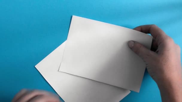 Ένα γυναικείο χέρι απλώνει δύο λευκά λευκά λευκά σεντόνια σε μπλε φόντο. — Αρχείο Βίντεο