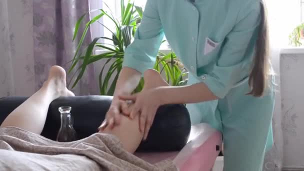 Mujer masajista hace masajes de las manos de las piernas con aceite en la oficina, las piernas de cerca. Médico haciendo masaje de pies de mujer, fisioterapia. — Vídeo de stock