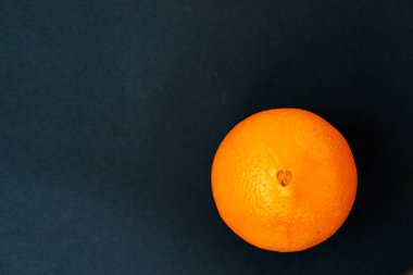 Siyah arka plan ve tebeşir tahtasında olgun bir portakal. Boşluğu kopyala.