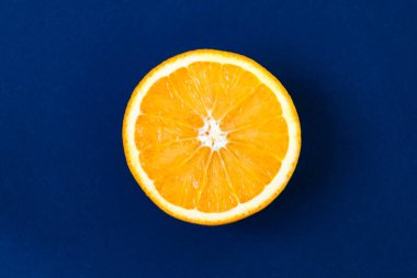 Parlak mavi arkaplanda turuncu bir meyve manzarası. Zengin narenciye dokusu. Boşluğu kopyala.