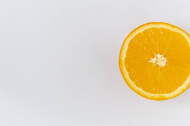 Beyaz arka planda turuncu yuvarlak bir meyvenin üst görüntüsü. Zengin narenciye dokusu. Boşluğu kopyala.