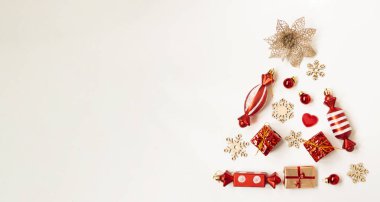 Farklı nesnelerden, kar tanelerinden, hediyelerden, beyaz arka planda şekerlerden oluşan bir Noel ağacının düz kompozisyonu. Boşluğu kopyala.