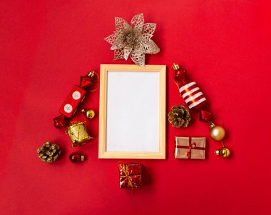Farklı ürünlerden, kar tanelerinden, hediyelerden, şekerlemelerden, kırmızı arka planda Noel ağacı süslemelerinden oluşan bir Noel ağacının olduğu düz kompozisyon. Model modeli. Boşluğu kopyala