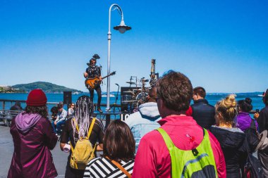 San Francisco, ABD: 30 Mart 2019: Fisherman 's Wharf' ta sokak sanatçısını izleyen insanlar