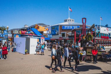 San Francisco, ABD: 30 Mart 2019: Balıkçı İskelesi 'nde iki yüzlü dükkanlar ve 39. rıhtımlar arasında yürüyen insanlar