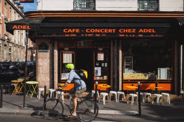 24 Haziran 2019 - Paris, Fransa: 10. Bölgede bir kafenin önünden bisikletle geçen adam