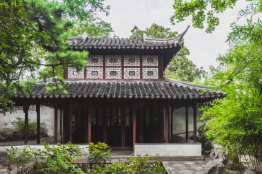 Çin 'in Jiangsu kentindeki Suzhou Bahçesi Sahne Bölgesi' ndeki ağaçlar arasındaki geleneksel Çin mimarisi.