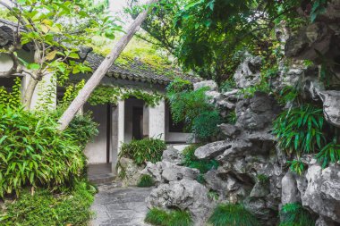Çin 'in Jiangsu kentindeki Suzhou Bahçesi Sahne Bölgesi' ndeki ağaçlar arasındaki geleneksel Çin mimarisi.