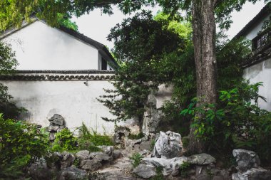 Çin 'in Jiangsu kentindeki Suzhou Bahçesi Sahne Bölgesi' ndeki ağaçlar arasındaki geleneksel Çin mimarisi.