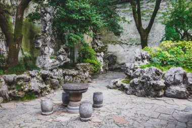 Suzhou, Jiangsu, Çin 'deki Bahçe Sahnesi' nde taş masa ve koltuklar.