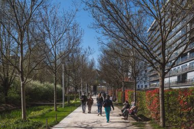 Paris, Fransa - 29 Mart 2021: Yerel halk, Martin-Luther-King Parkı 'nda güneşli bir öğleden sonranın keyfini çıkarıyor.