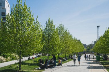 Paris, Fransa - 25 Nisan 2021: Yerel halk Martin-Luther-King Parkı 'nda üçüncü ulusal tecrit sırasında güneşli bir öğleden sonra geçiriyor
