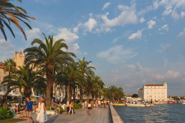 Split, Hırvatistan - 11 Ağustos 2015: İnsanlar alacakaranlıkta Riva gezinti alanı boyunca yürüyor