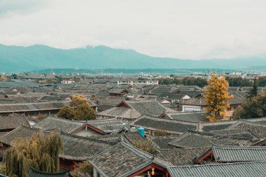Çin 'in eski Lijiang kentinin geleneksel evleri ve dağ manzarası.