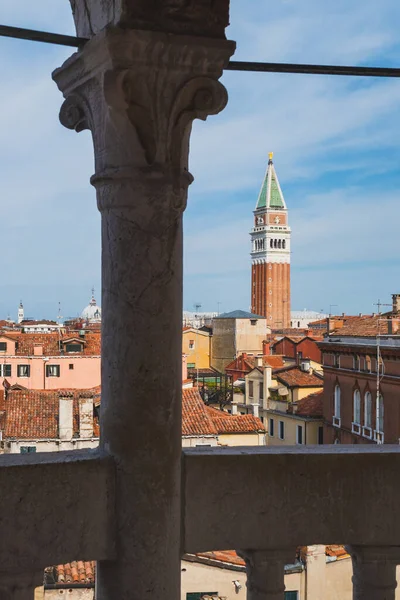 イタリアのヴェネツィアの列の間で見られる伝統的なヴェネツィアの家の上のサン マルコ鐘楼の眺め — ストック写真