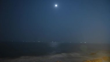 Ay 'ın, gece gökyüzünde Arap Denizi' nin üzerinde hareket eden, büyüleyici, yüksek kalitede bir zaman atlaması. Kannur, Kerala kıyılarından yakalandı.