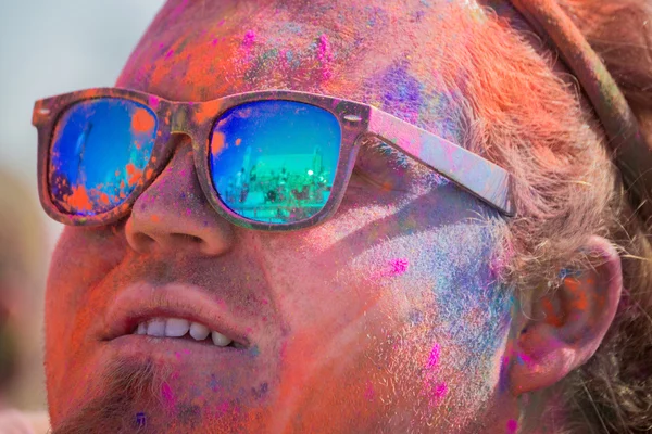 Unknown man with painted face and glasses looking at the stage — Stock Photo, Image