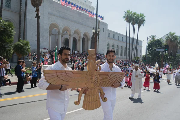 Men holding a sculpture of Faravahar, Iranian symbol — Stock Photo, Image