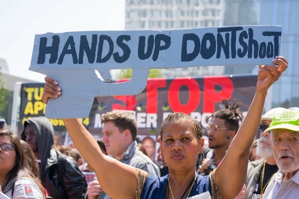 Woman raising a sign in the form of a gun — Stock Photo, Image