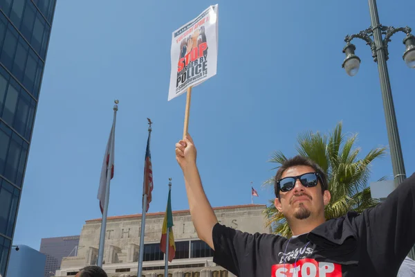 Hombre usando stop murder por la camisa de policía y sosteniendo el cartel —  Fotos de Stock