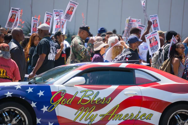 Car painted with american flag colors in front of protestors — Stock Photo, Image