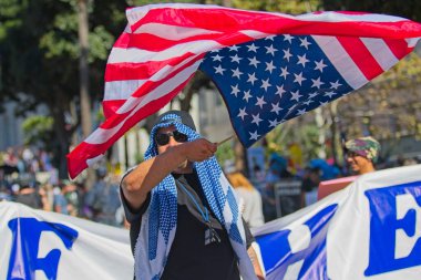 Los Angeles, Kaliforniya, ABD, 18 Ekim 2025. Protestocular, Krallar Yok kampanyası sırasında, Trump yönetim politikalarını protesto eden, demokrasi ve göçmen haklarına destek veren bayraklar ve pankartlar taşıyorlar..