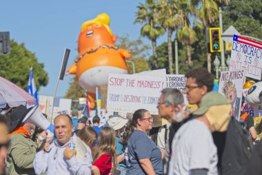 Los Angeles, Kaliforniya, ABD, 18 Ekim 2025. Trump maskesi takan bir adam, Trump yönetim politikalarını protesto eden, demokrasi ve göçmen haklarına destek veren Kralsız protestocular olarak görülüyor..