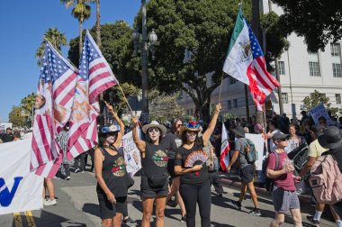 Los Angeles, Kaliforniya, ABD, 18 Ekim 2025. Protestocular, Krallar Yok kampanyası sırasında, Trump yönetim politikalarını protesto eden, demokrasi ve göçmen haklarına destek veren bayraklar ve pankartlar taşıyorlar..