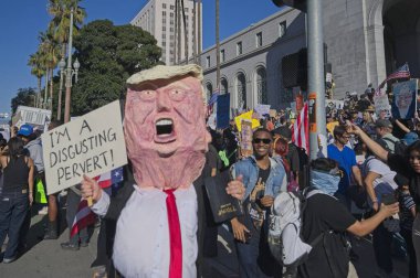 Los Angeles, Kaliforniya, ABD, 18 Ekim 2025. Trump maskesi takan bir adam, Trump yönetim politikalarını protesto eden, demokrasi ve göçmen haklarına destek veren Kralsız protestocular olarak görülüyor..