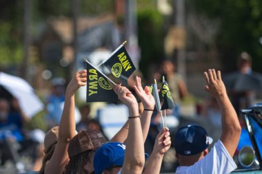 Los Angeles, California, ABD, 11 Kasım 2025 San Fernando Vadisi Gaziler Günü sırasında elinde ordu bayrakları tutan insanlar.