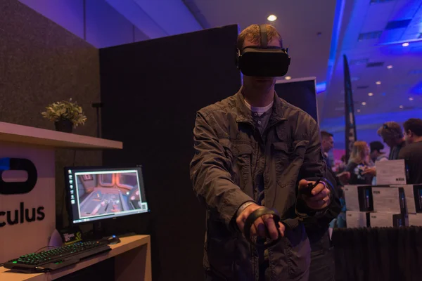 Man tries virtual reality headset and hand controls — Stockfoto